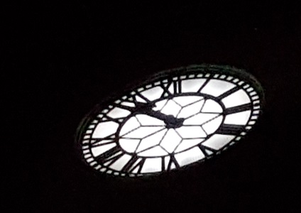 Back-lit clock-tower's face in dark night