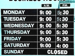 Generic sign displaying business hours for local shop